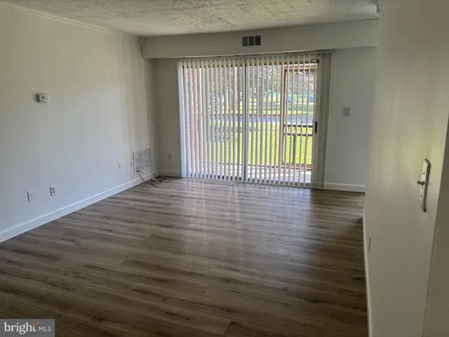 a view of a room with wooden floor and a window