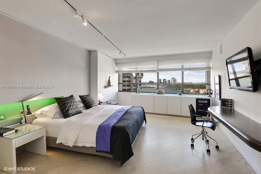 2 Grove Isle Drive, Unit B1708 Miami, FL 33133 - Photo 11 of 30 a bedroom with a bed window table chair and glass door