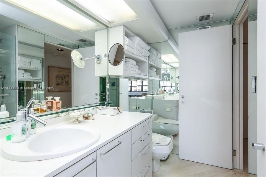 2 Grove Isle Drive, Unit B1708 Miami, FL 33133 - Photo 13 of 30 a bathroom with a sink a toilet and a mirror