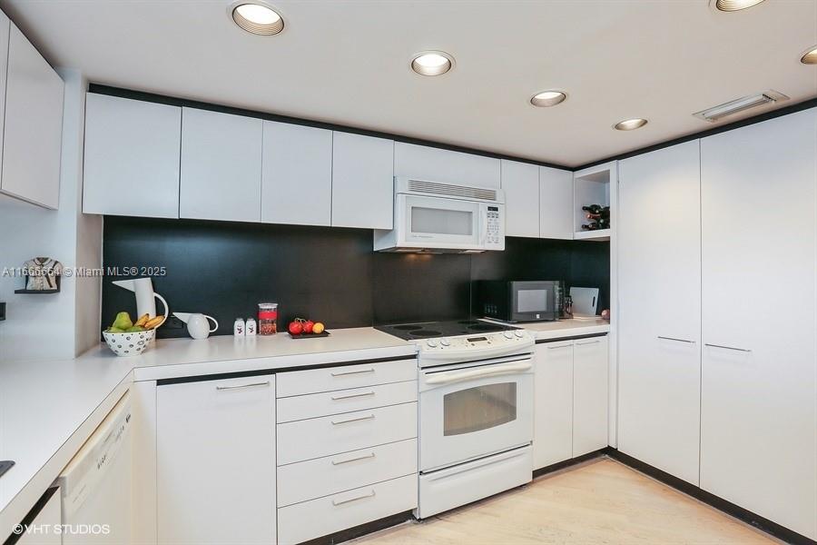 2 Grove Isle Drive, Unit B1708 Miami, FL 33133 - Photo 8 of 30 a kitchen with white cabinets and white appliances
