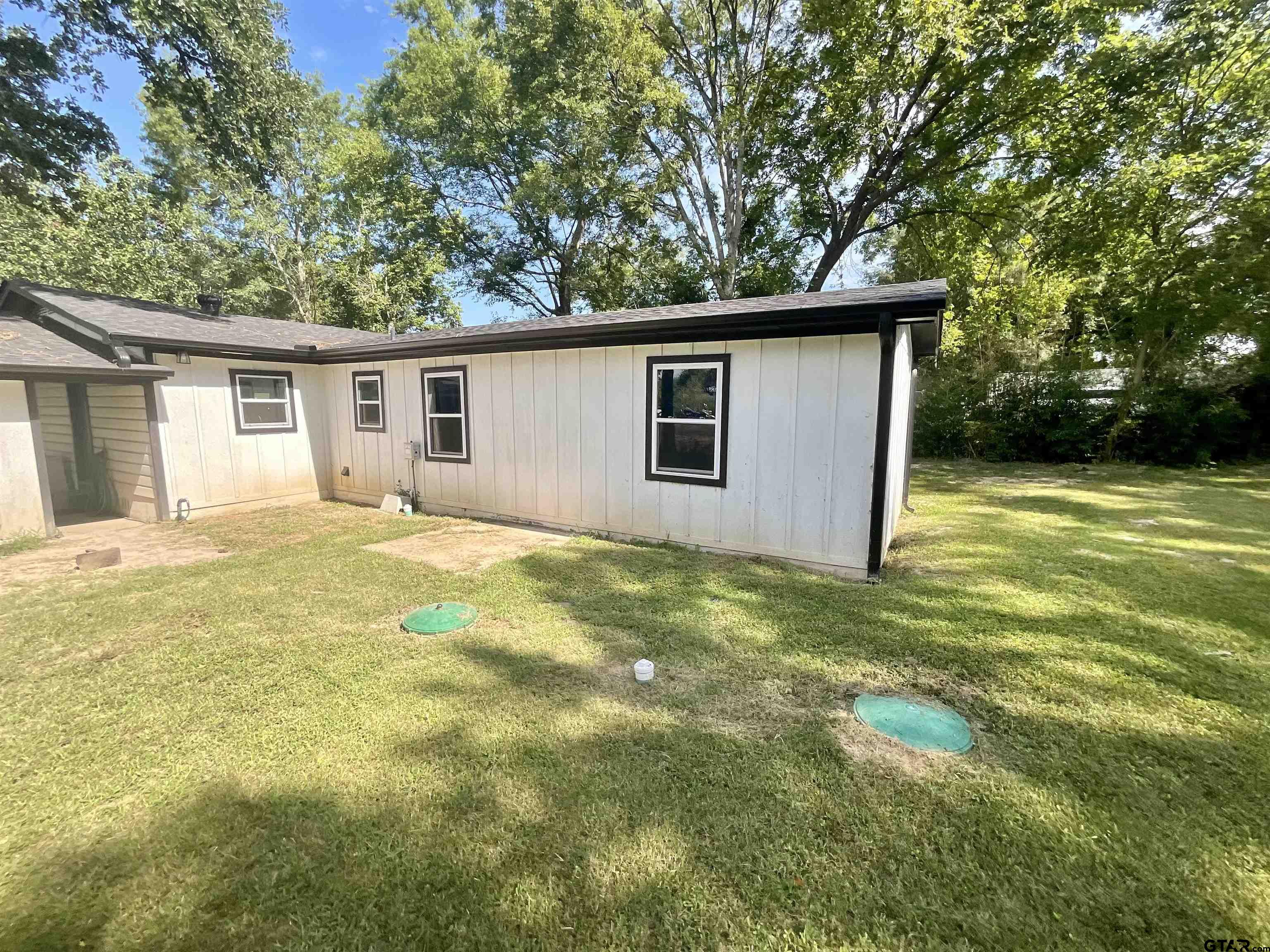 151 Patton Lane Tyler, TX 75704 - Photo 23 of 26 a backyard of a house with large trees and plants
