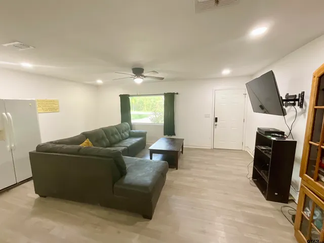 a large kitchen with kitchen island a dining table chairs and a refrigerator
