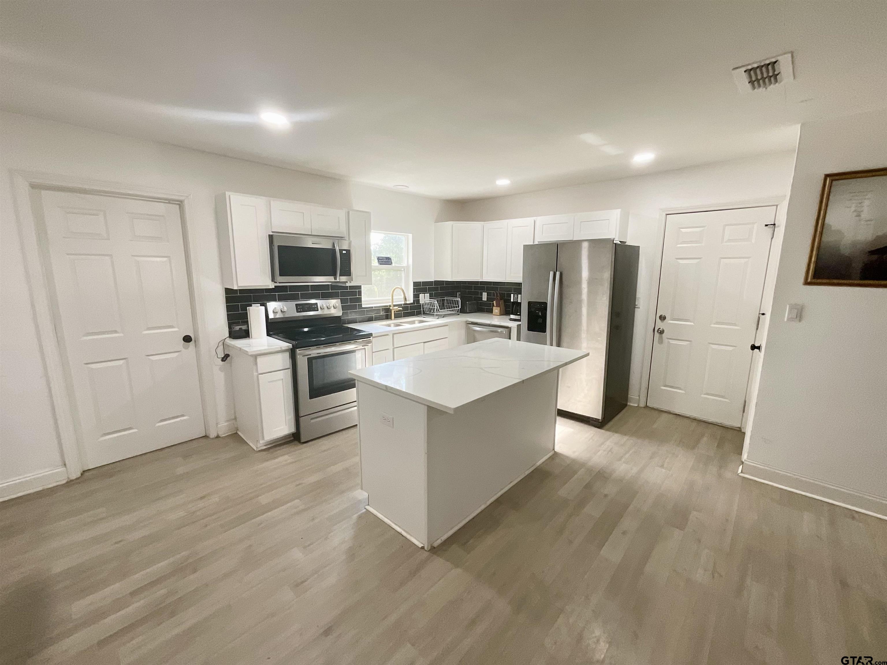 151 Patton Lane Tyler, TX 75704 - Photo 7 of 26 a large kitchen with a refrigerator a stove top oven a sink and dishwasher