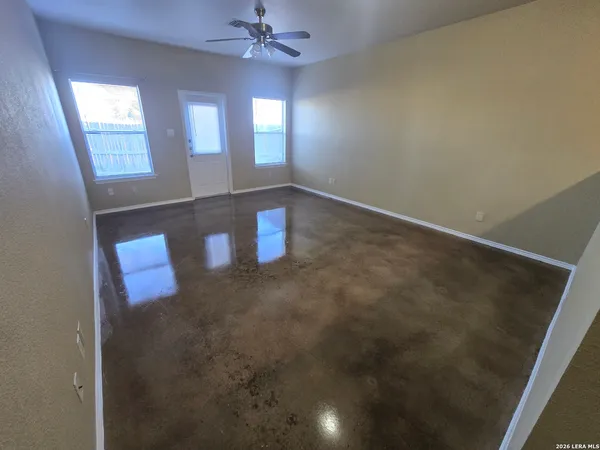 en empty room with window and chandelier fan
