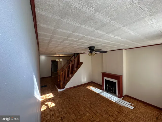 a view of empty room with wooden floor and fireplace
