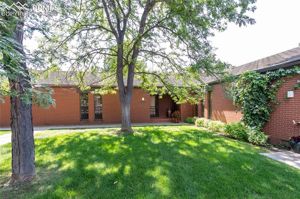 2650 Spring Grove Terrace Colorado Springs, CO 80906 - Photo 1 of 35 Front view of property featuring brick siding and a yard