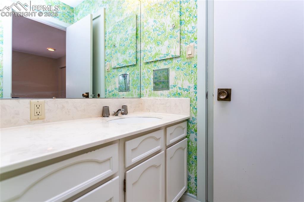 2650 Spring Grove Terrace Colorado Springs, CO 80906 - Photo 24 of 35 Bathroom with wallpapered walls and vanity