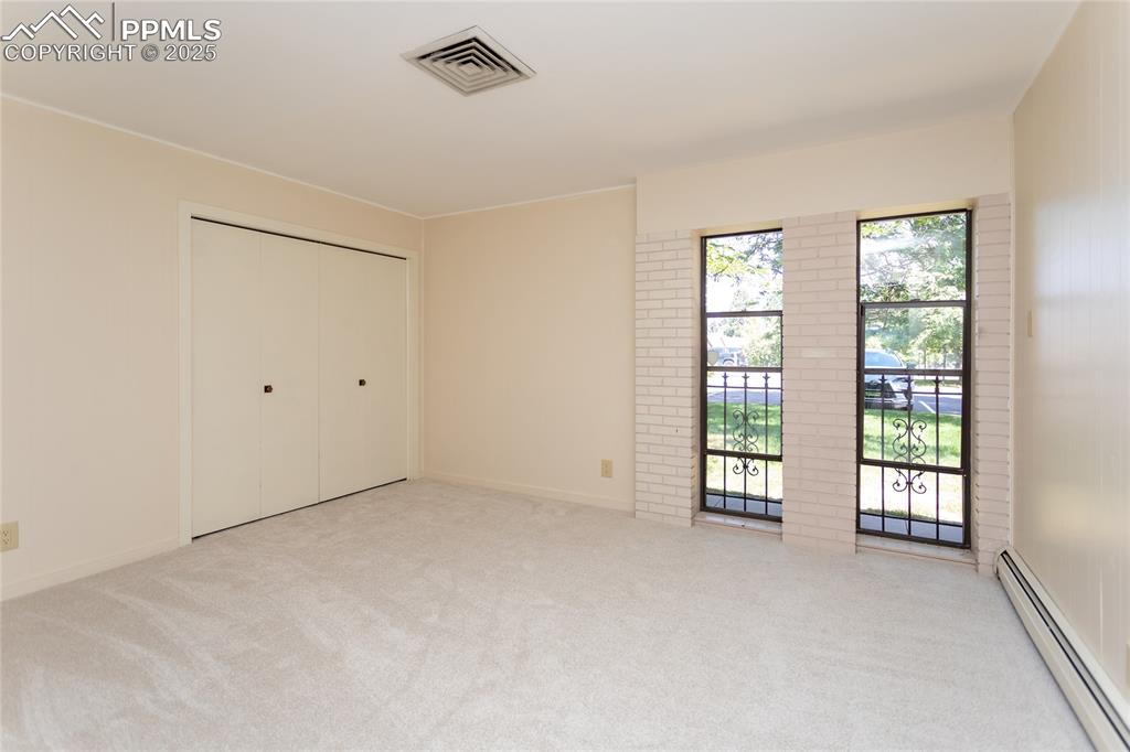 2650 Spring Grove Terrace Colorado Springs, CO 80906 - Photo 25 of 35 Unfurnished bedroom featuring a baseboard radiator, light carpet, and a closet