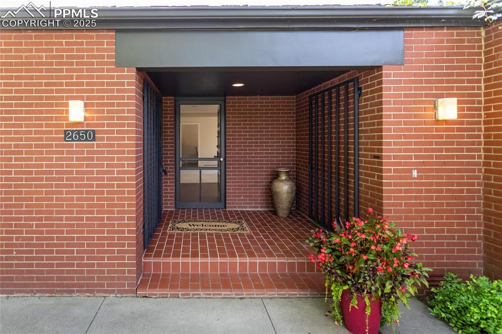 2650 Spring Grove Terrace Colorado Springs, CO 80906 - Photo 34 of 35 View of exterior entry featuring brick siding and a porch