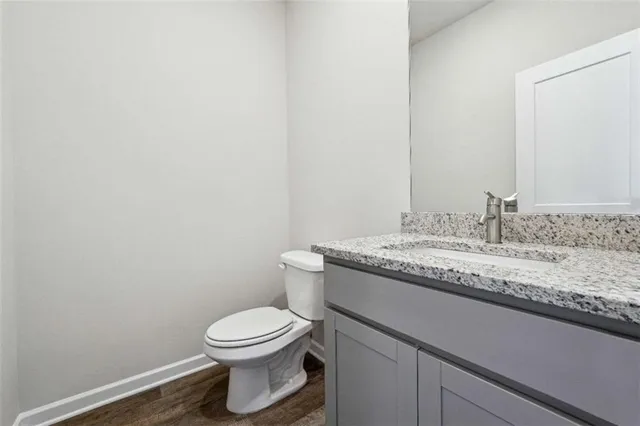 a bathroom with a granite countertop toilet and a sink