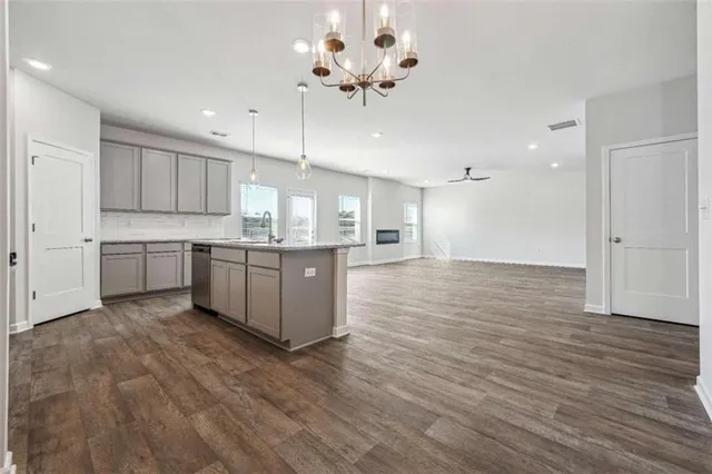 a large kitchen with wooden floors and white cabinets