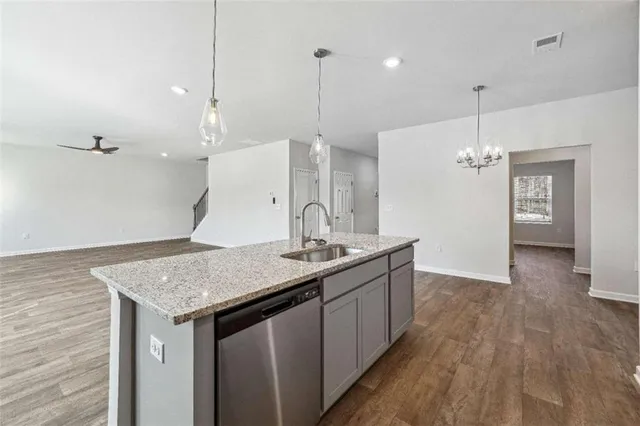 a kitchen with a sink a counter space and wooden floor