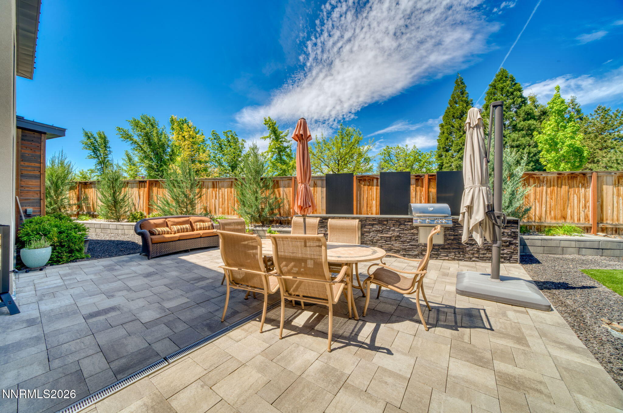 6141 Triple Crown Drive Reno, NV 89511 - Photo 25 of 71 a view of a patio with table and chairs potted plants and palm trees