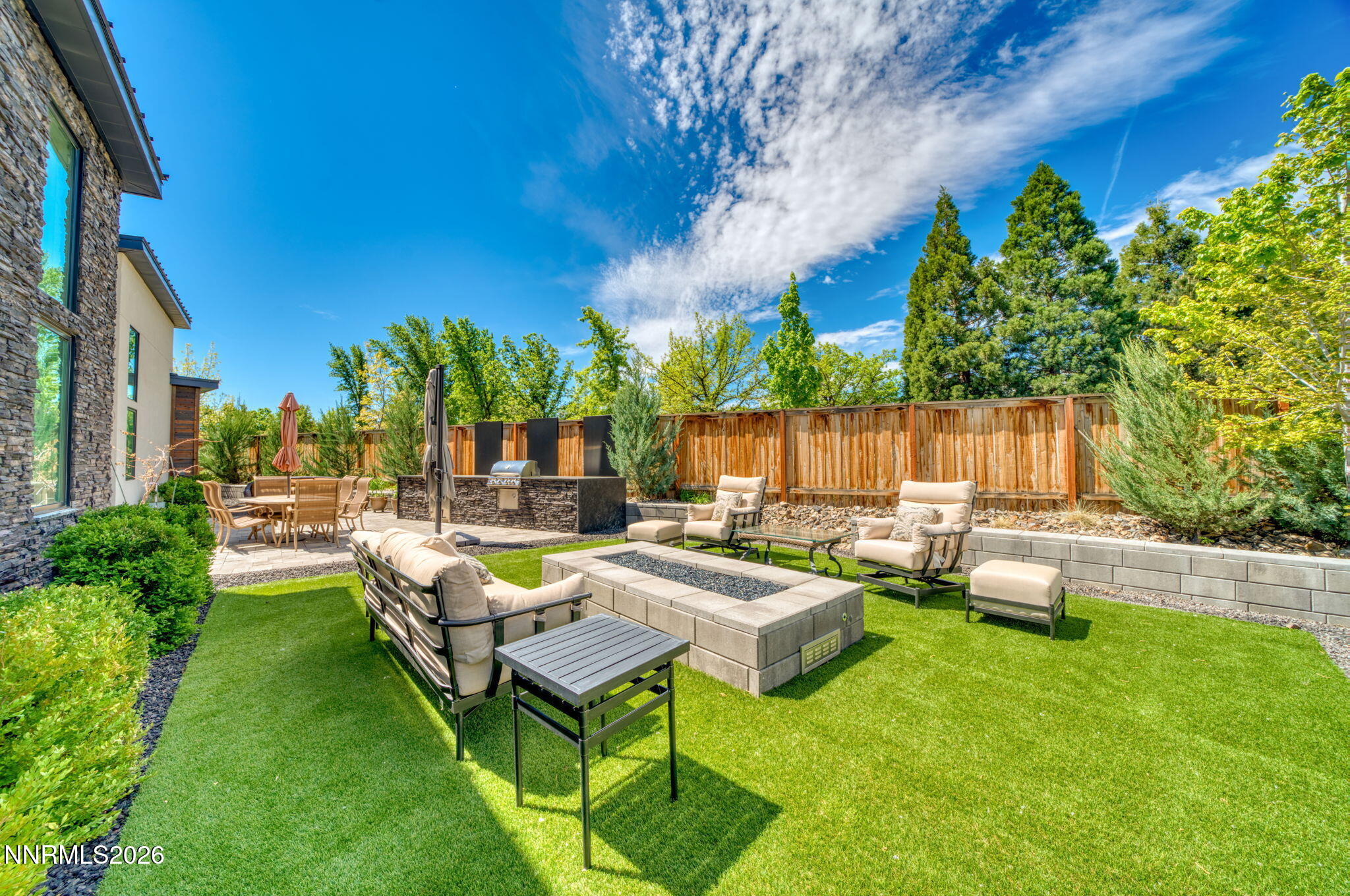6141 Triple Crown Drive Reno, NV 89511 - Photo 31 of 71 a view of a patio with couches chairs and a fire pit and an umbrella