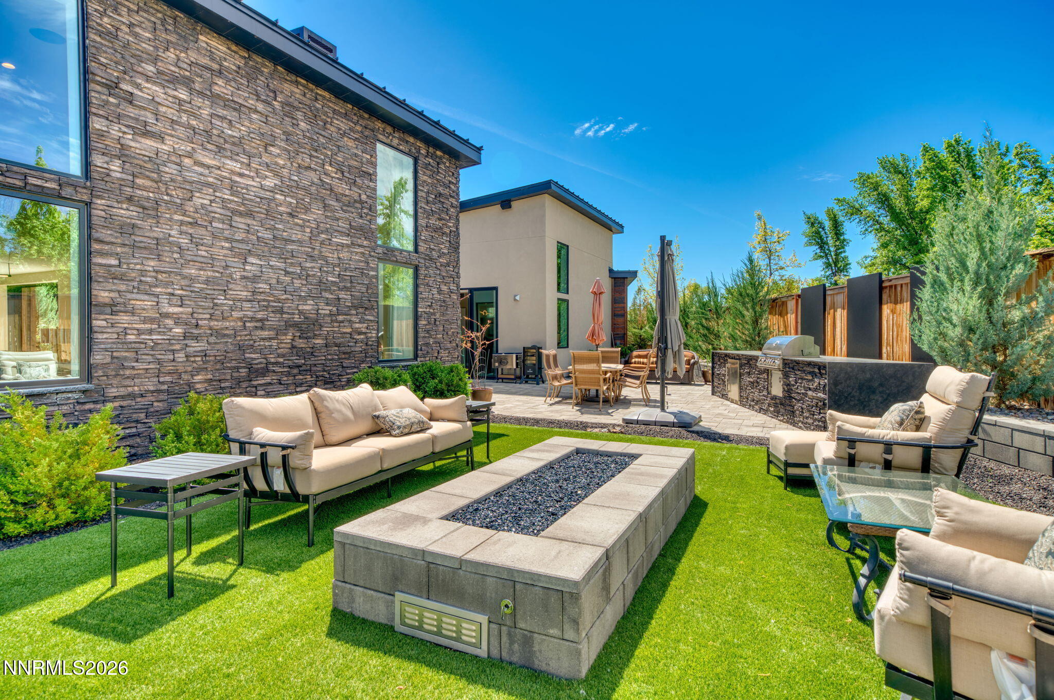 6141 Triple Crown Drive Reno, NV 89511 - Photo 32 of 71 a view of a patio with couches and a table and chairs with plants and wooden fence