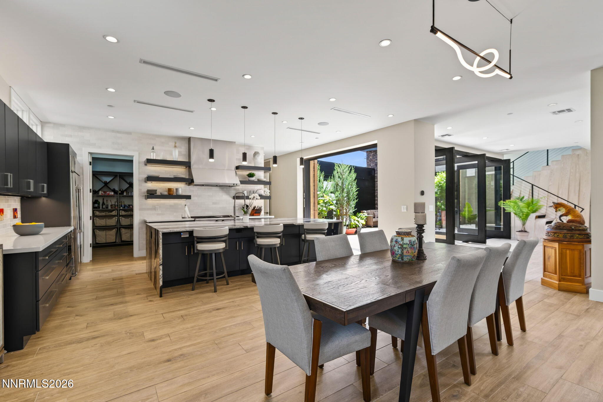 6141 Triple Crown Drive Reno, NV 89511 - Photo 37 of 71 a dining room with kitchen island furniture a chandelier stainless steel appliances and wooden floor