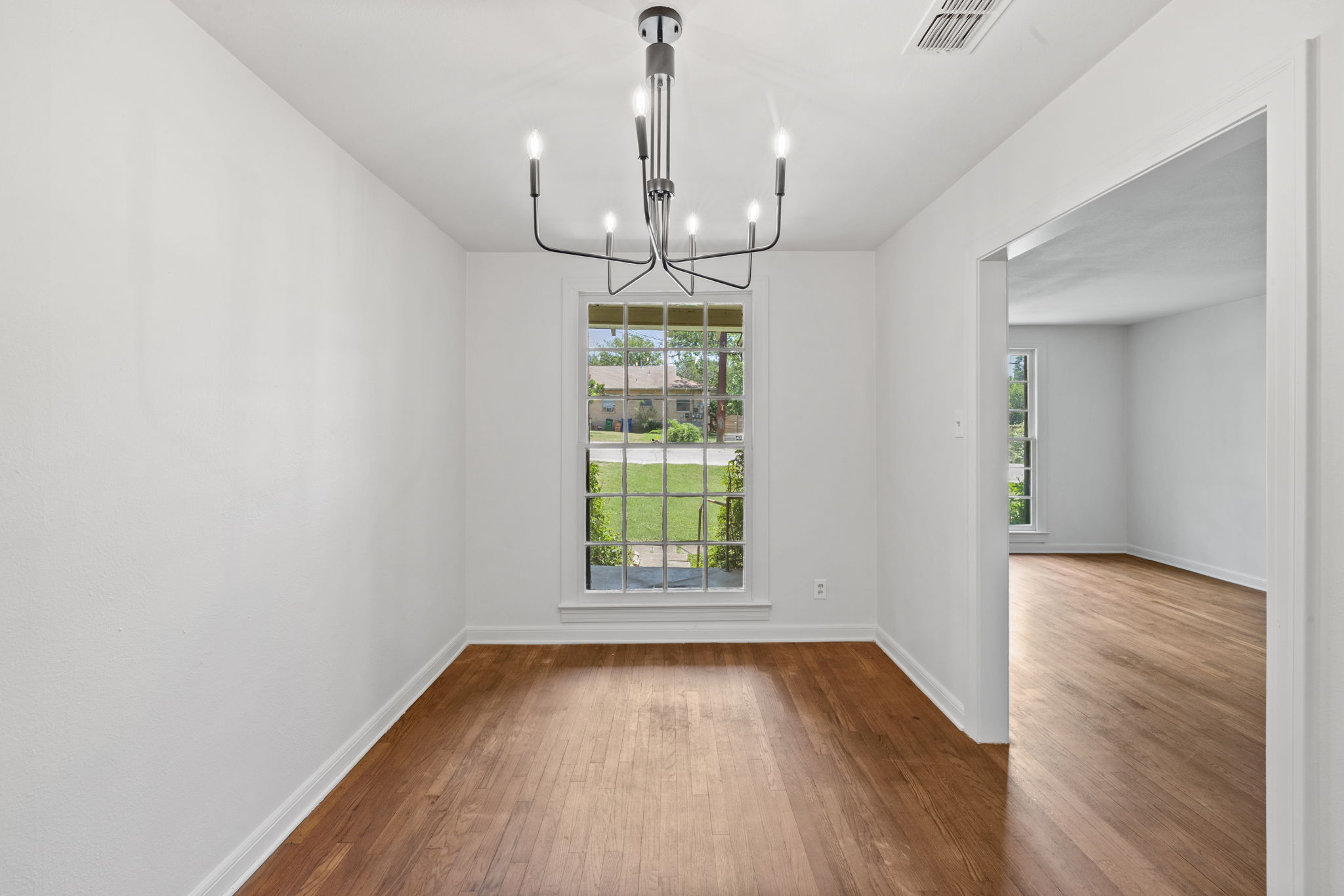 3704 Cherrywood Road Austin, TX 78722 - Photo 11 of 40 A well-lit dining area features hardwood flooring and a chandelier.