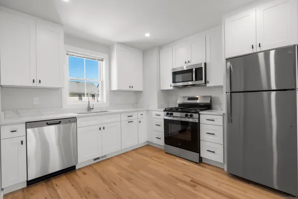 a kitchen with granite countertop white cabinets and stainless steel appliances