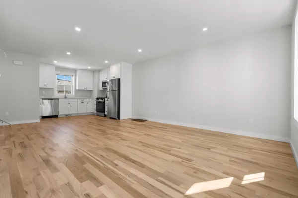 a view of empty room with wooden floor