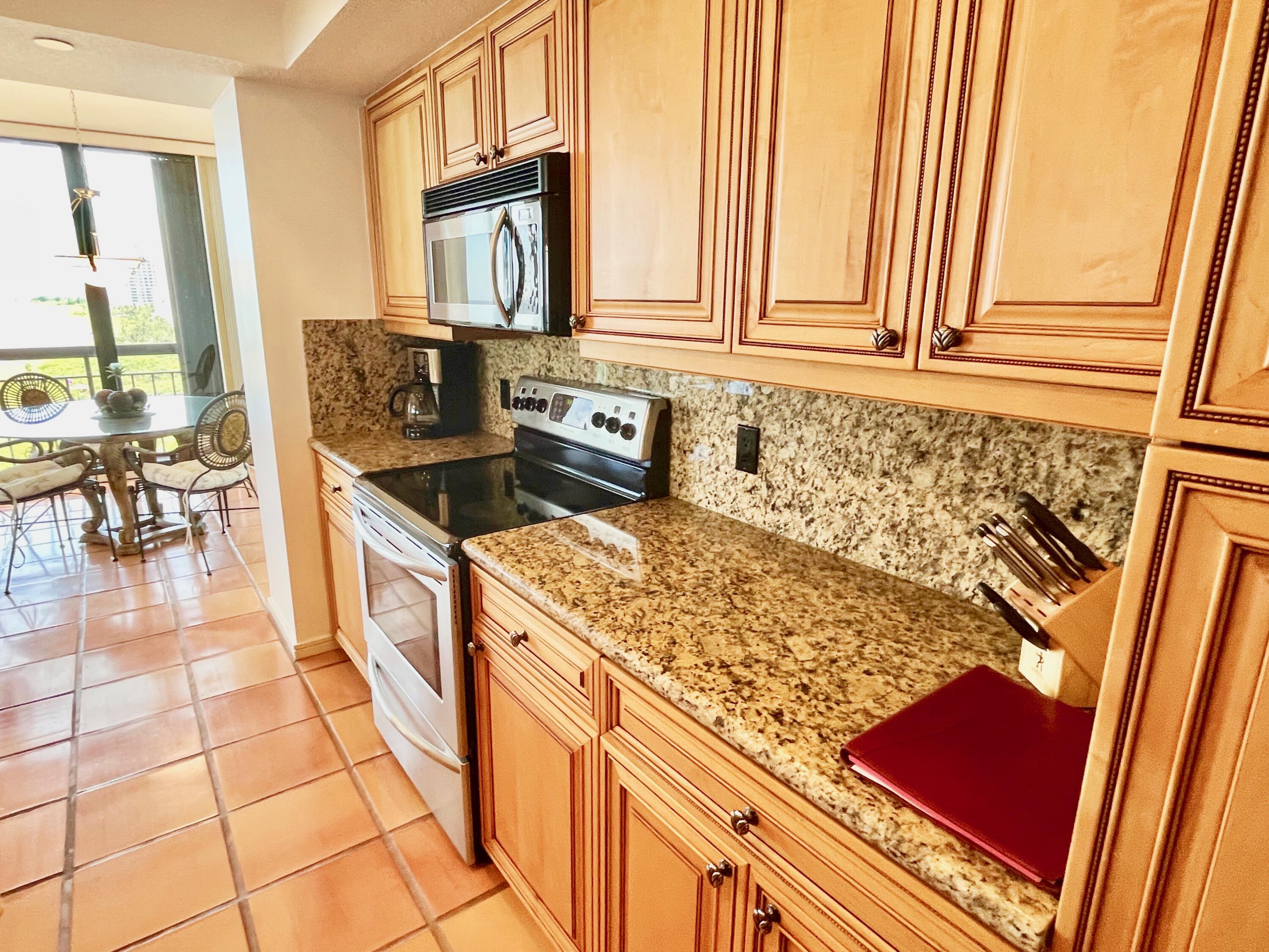 4000 North Ocean Drive, Unit 902 Singer Island, FL 33404 - Photo 16 of 53 a kitchen with stainless steel appliances granite countertop a stove a sink and a microwave