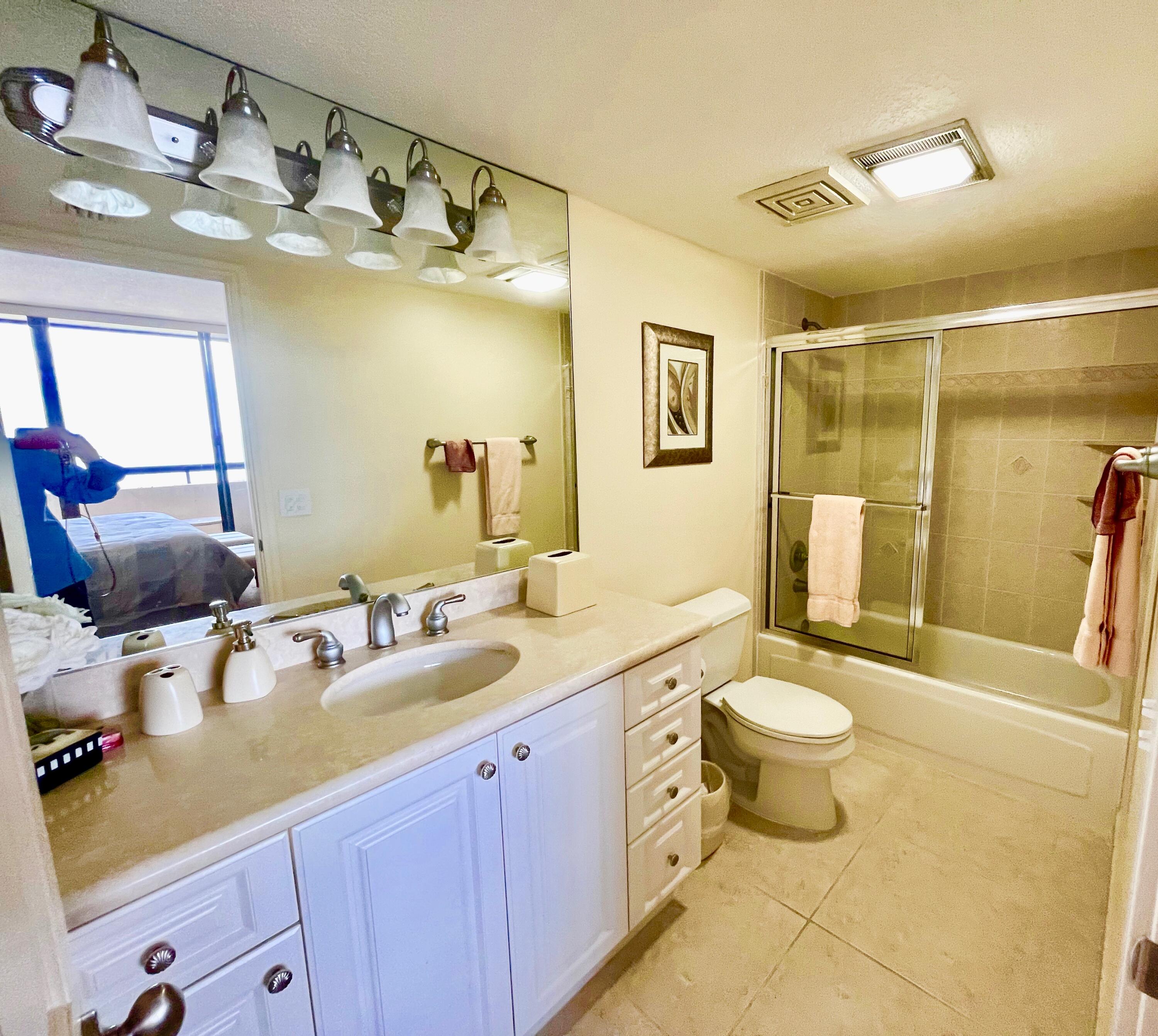 4000 North Ocean Drive, Unit 902 Singer Island, FL 33404 - Photo 28 of 53 a bathroom with a granite countertop sink mirror vanity and toilet