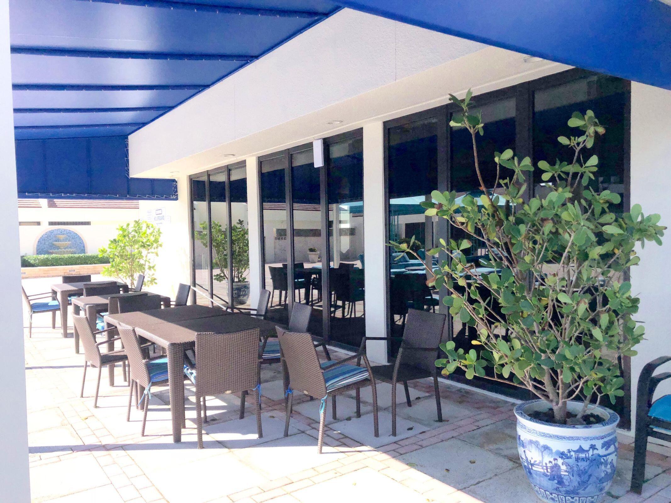 4000 North Ocean Drive, Unit 902 Singer Island, FL 33404 - Photo 36 of 53 a view of a patio with table and chairs potted plants and floor to ceiling window