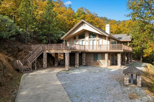 a front view of a house with a yard and trees