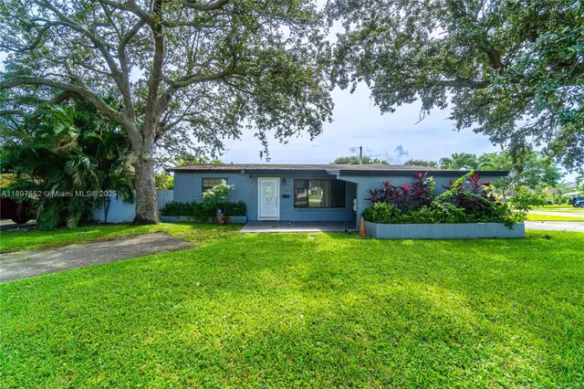 a front view of a house with a garden and trees
