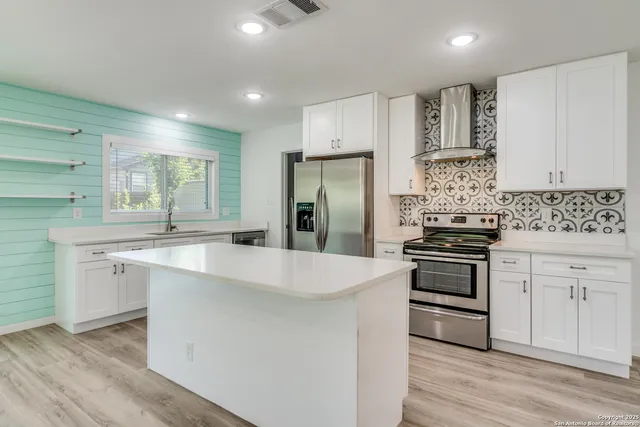 a kitchen with stainless steel appliances a sink stove and refrigerator