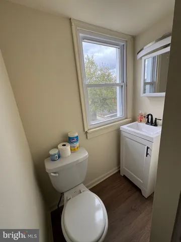 a bathroom with sink toilet mirror and window
