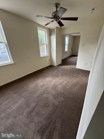 a view of a livingroom with a ceiling fan and window