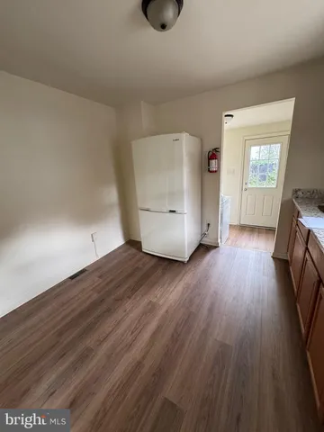 a view of empty room with wooden floor and window