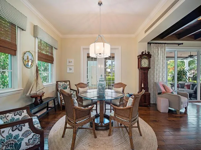 a dining room with furniture a chandelier and wooden floor