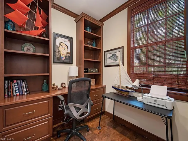 a view of a workspace with furniture and a window