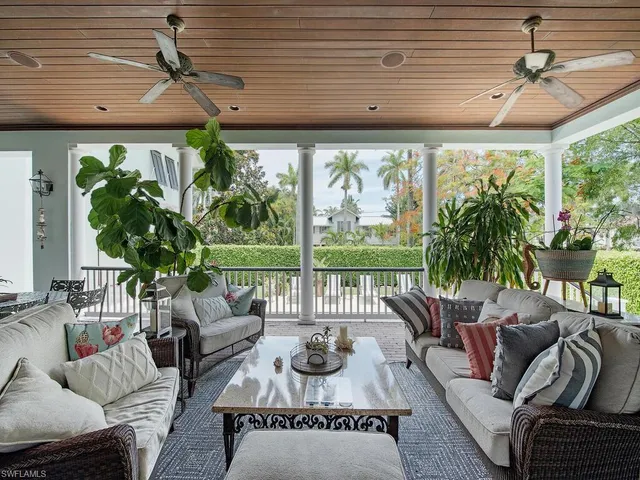 a living room with patio furniture and a potted plant