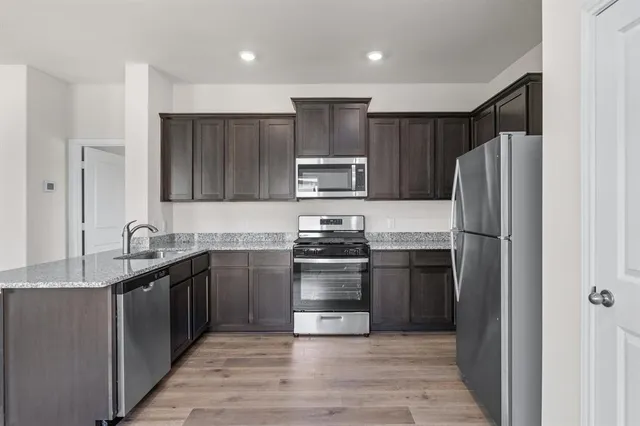 a kitchen with granite countertop stainless steel appliances and wooden cabinets