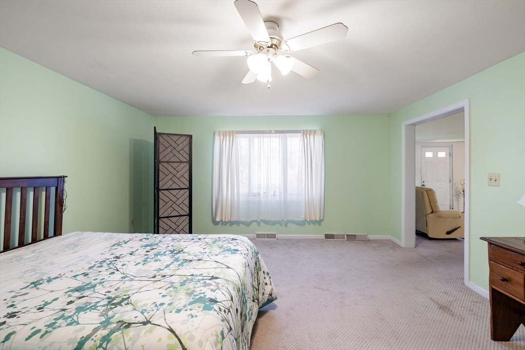 111 Thaddeus Street Chicopee, MA 01020 - Photo 15 of 32 a spacious bedroom with a bed and a chandelier