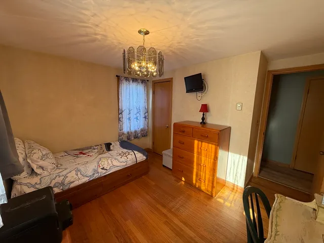 a bedroom with a bed and a chandelier