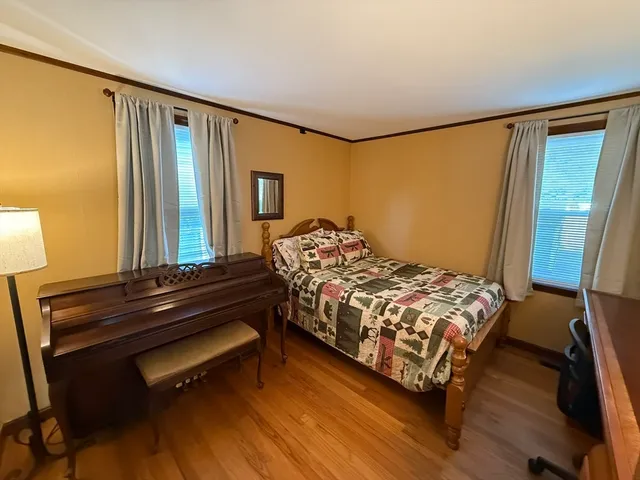 a bedroom with a bed window and a dresser