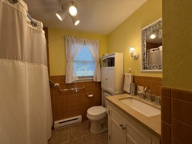 a bathroom with a granite countertop sink toilet a mirror and shower