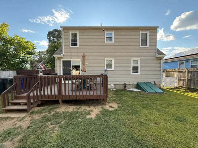 a view of a house with a wooden deck and a yard