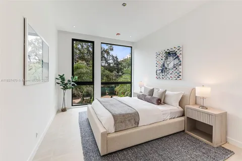 a bedroom with a large bed and a window