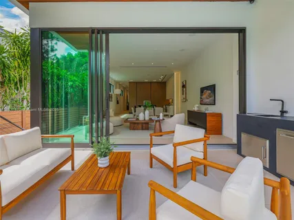 a view of a patio with table and chairs potted plants with floor to ceiling window