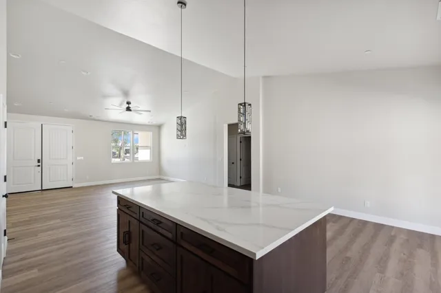 a kitchen with kitchen island a sink appliances and wooden floor