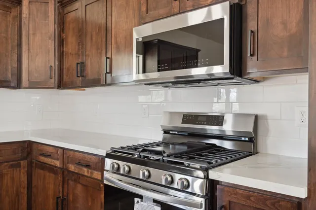 a kitchen with granite countertop a stove and a microwave