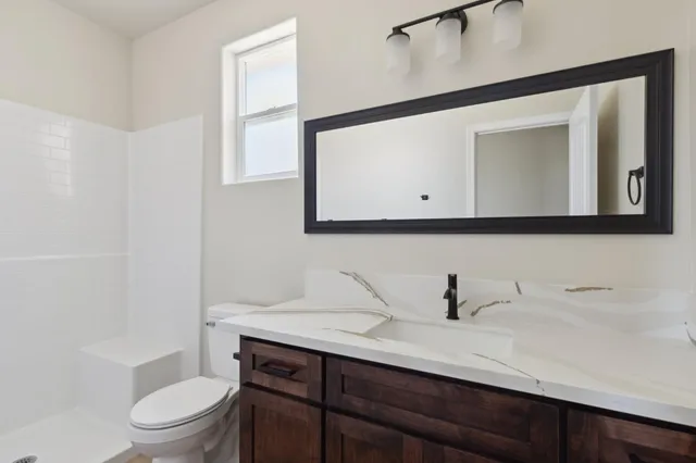 a bathroom with a toilet a sink and mirror