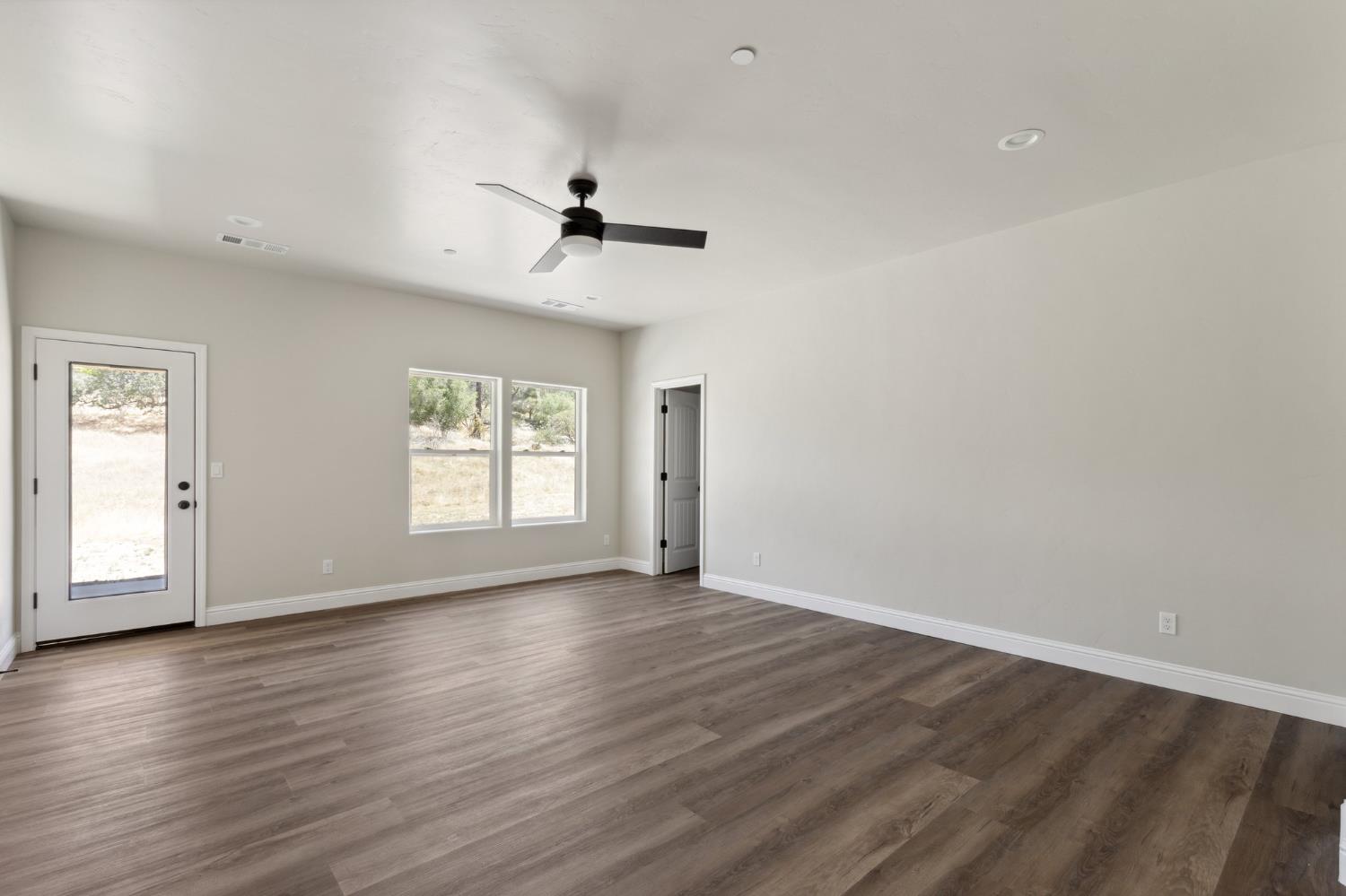 31007 Revis Road Coarsegold, CA 93614 - Photo 21 of 41 a view of empty room with wooden floor and fan