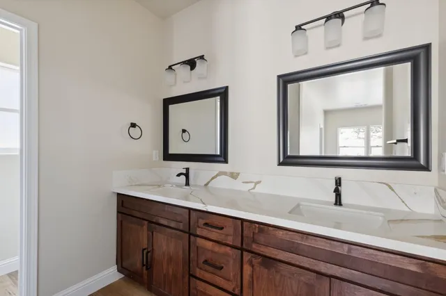 a bathroom with a double vanity sink and mirror