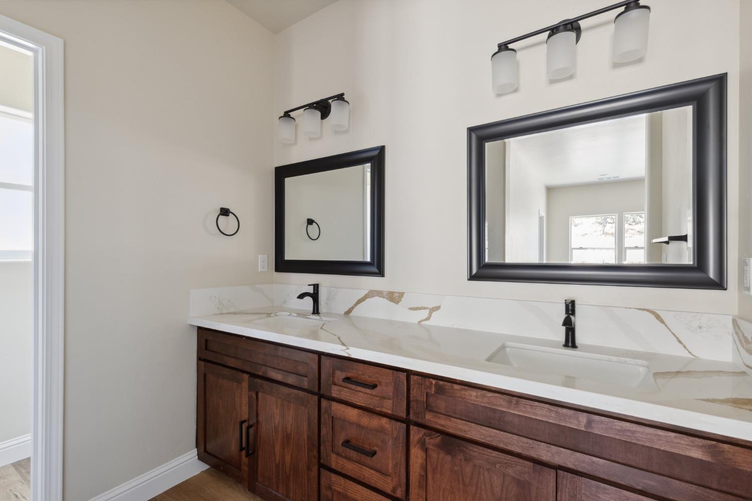 31007 Revis Road Coarsegold, CA 93614 - Photo 24 of 41 a bathroom with a double vanity sink and mirror