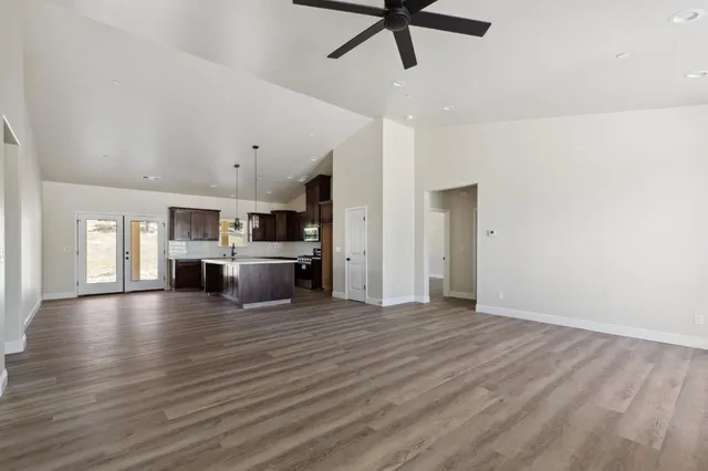 a view of a kitchen with a stove wooden cabinets and entryway